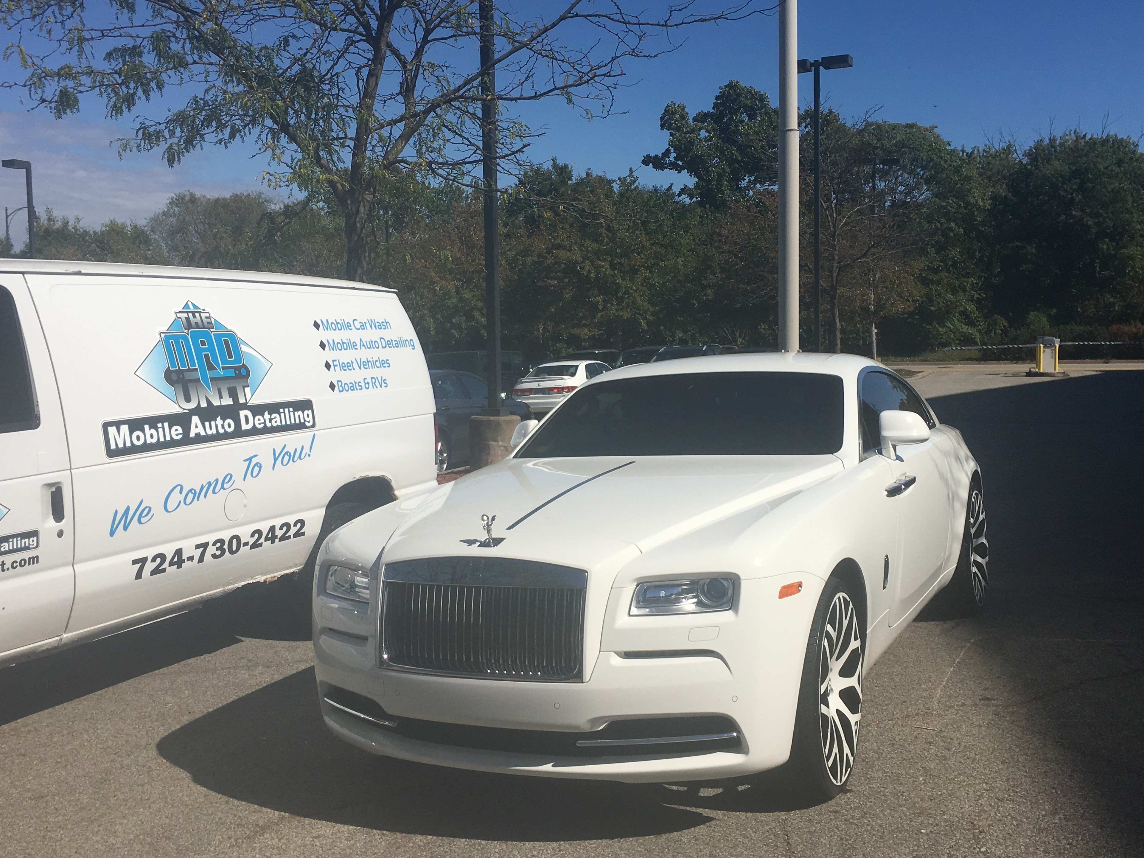 White Rolls-Royce front view with MAD Unit van